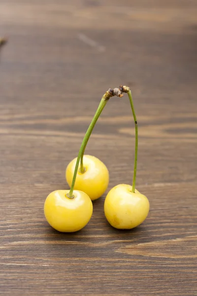 Fresh yellow cherry on a wooden background, selective focus — Stok fotoğraf