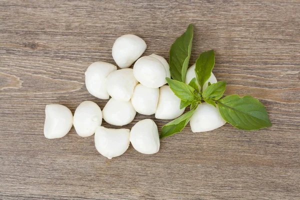 Mini-Mozzarella-Bällchen mit grünen Basilikumblättern, horizontaler Schuss, selektiver Fokus — Stockfoto