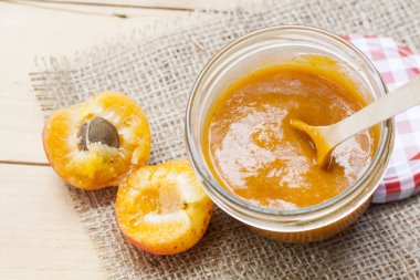 Ev yapımı kayısı reçeli ve ahşap masa yapraklarda ile taze kayısı