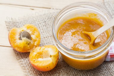 Ev yapımı kayısı reçeli ve ahşap masa yapraklarda ile taze kayısı