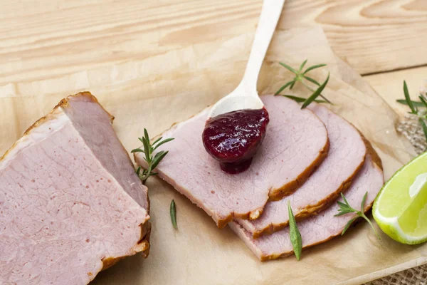 Gerookt vlees, rozemarijn, huisgemaakte organische cherry confiture en kalk op een houten tafel — Stockfoto