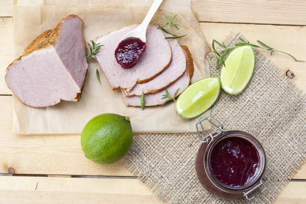 Huisgemaakte confiture organische cherry jam, gerookt vlees en kalk op een houten tafel — Stockfoto