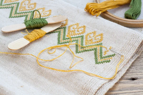 Bordado ucraniano en la tela de lino y bordado de hilo en una mesa de madera, enfoque selectivo — Foto de Stock
