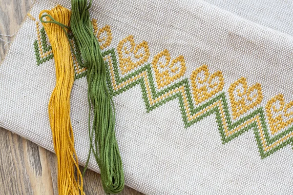 Bordado ucraniano en la tela de lino y bordado de hilo en una mesa de madera, enfoque selectivo — Foto de Stock