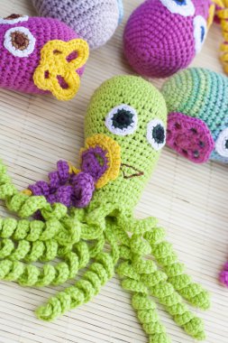 Crocheted woven with colored wool toy octopus close-up, selective focus