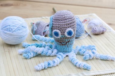 Crocheted woven with colored wool toy octopus close-up, selective focus
