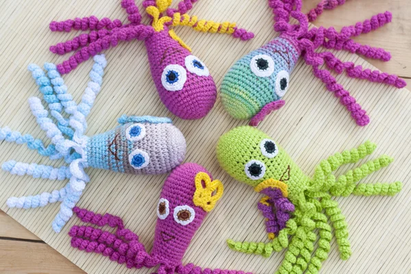 Crocheted woven with colored wool toy octopus close-up, selective focus