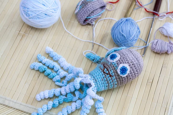 Crocheted woven with colored wool toy octopus close-up, selective focus — Stock fotografie