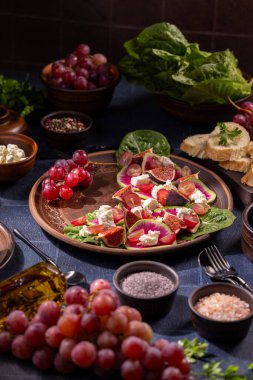 Canlı Akdeniz salatası taze incir, üzüm, parçalanmış feta ve karpuz turpu, zeytinyağı ve baharatlı kırsal seramik tabağı, stüdyoyu kapatın.