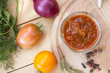 Homemade tomato sauce in glass jar with fresh tomatos, garlic, onion, herbs and spices, close up, selective focus