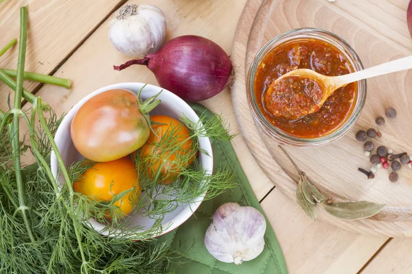 Homemade tomato sauce in glass jar with fresh tomatos, garlic, onion, herbs and spices, close up, selective focus — Stock Photo, Image