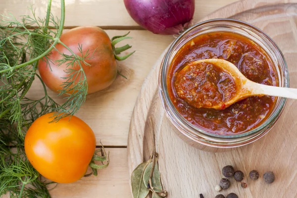 Homemade tomato sauce in glass jar with fresh tomatos, garlic, onion, herbs and spices, close up, selective focus — Stock Photo, Image