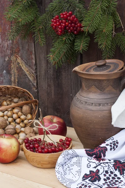 Outono ainda vida em estilo ucraniano panela de barro e baga de outono e legumes no velho fundo de madeira, close-up — Fotografia de Stock