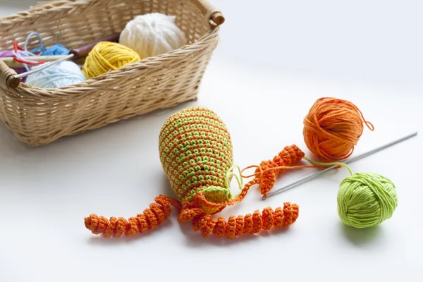 Making of handmade colorful crochet toys sweets (key ring) with skein on wooden table. Selective focus.