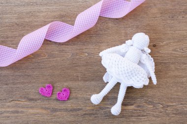 Valentines day crochet hearts and angel and ribbon on wooden table