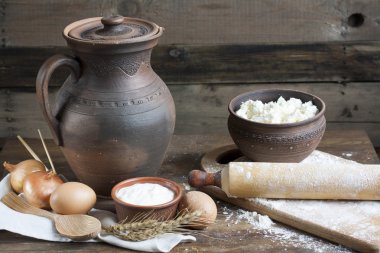 Rustik doğal süt ürünleri. Rustik doğal süt ürünleri süzme peynir, ekşi krema kil yemekleri, yumurta ve kulakları buğday eski ahşap arka plan üzerinde.