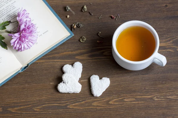 Cup of hot tea with books and flowers and cookies. — Stock Photo, Image