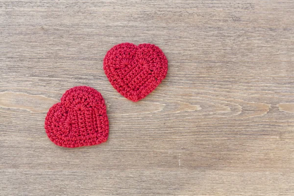 Two red crochet hearts on wooden background for Valentines day — Zdjęcie stockowe