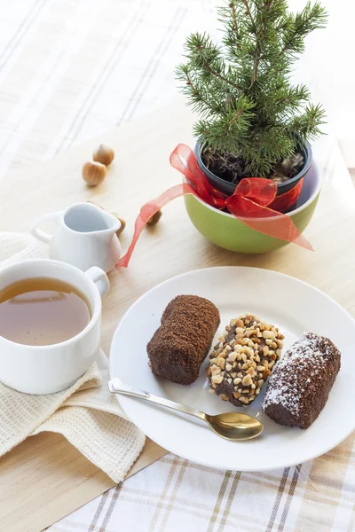 Té verde caliente fresco en taza blanca con pasteles de chocolate en cesta . —  Fotos de Stock