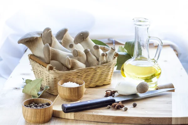Кошик з грибами, оливковою олією та інгредієнтами для приготування на дерев'яному столі кухонного фону — стокове фото