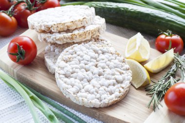 Düz pirinç kek, Galette'ye pirinç sebze ahşap tahta üzerinde biberiye ve limon ile