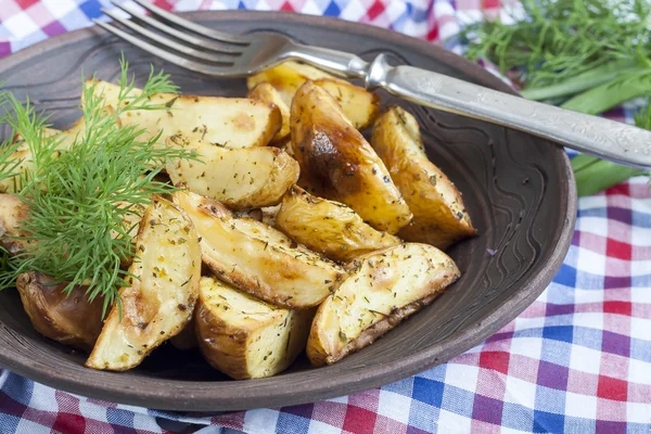 Délicieuses pommes de terre frites au four avec aneth dans une assiette blanche sur la table — Photo