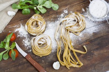 Ham ev yapımı makarna, Bıldırcın yumurta alüminyum Kupası, yeşil salata, domates ve un ahşap tablo içinde
