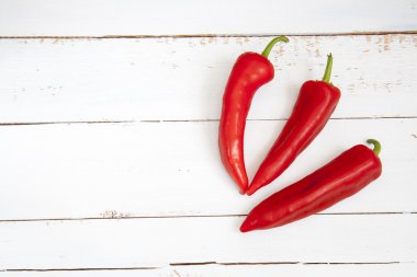 Tatlı kırmızı biber kapı, üç beyaz tahta masada biber