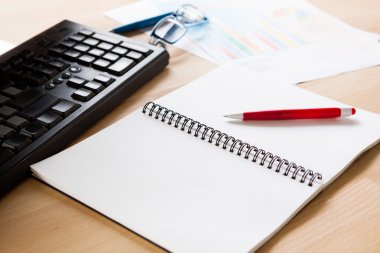 Çalışma masası açık kitabın beyaz sayfasında kırmızı kalem vurur 