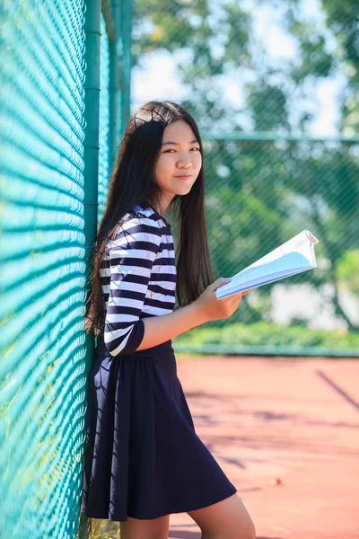 Asiático chica y escuela libro en mano toothy sonriendo cara con happ — Foto de Stock