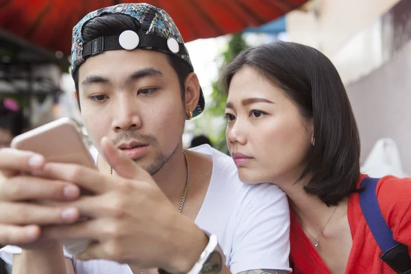 Ásia mais jovem homem e mulher assistindo no inteligente telefone uso para peop — Fotografia de Stock