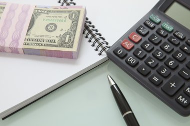 banknot ve kalem calculater not defterindeki yığını
