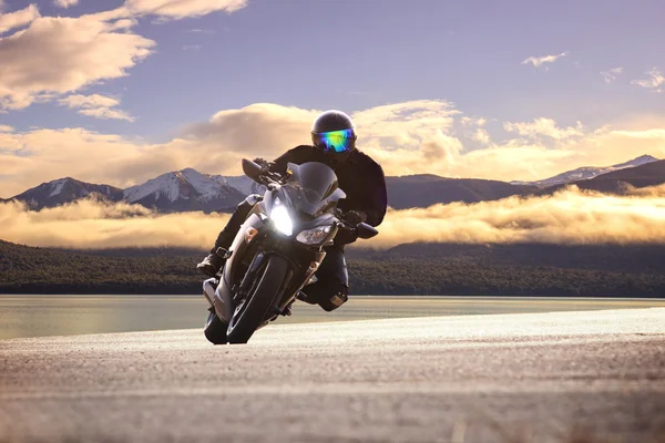 Joven hombre montando moto grande contra la curva aguda de asph — Foto de Stock