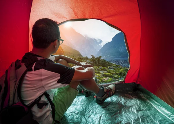 Camping man in camper tent looking to beautiful natural water fa — Stock Photo, Image