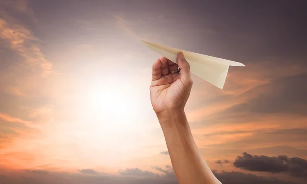 Voorbereiding van de hand met het gooien van papier vliegtuig tot medio lucht againt groene g — Stockfoto