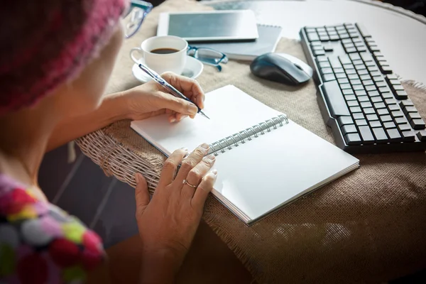 Frau schreibt Erinnerungsnotiz auf weißem Papier mit entspanntem Ti — Stockfoto