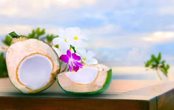 Kvarterens hälften av gröna kokos vatten på trä bord med tropica — Stockfoto