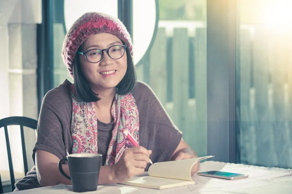 40s years old asian woman relaxing reading and drinking coffee i — Stock Photo, Image