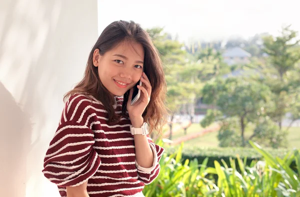 Jonge Aziatische vrouw praten over slimme telefoon met geluk emtion — Stockfoto