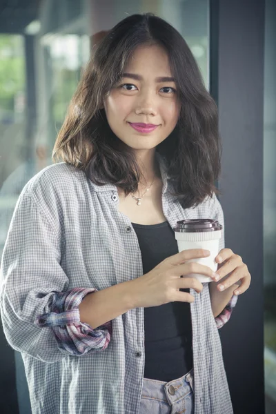 Aziatische vrouw en warme koffie beker in de hand ontspannen emotie glimlachen — Stockfoto