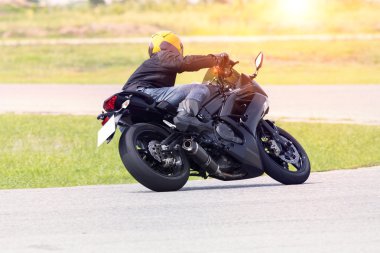 genç adam asfalt yol eğrisindeki tam s giyiyor motosiklet binme