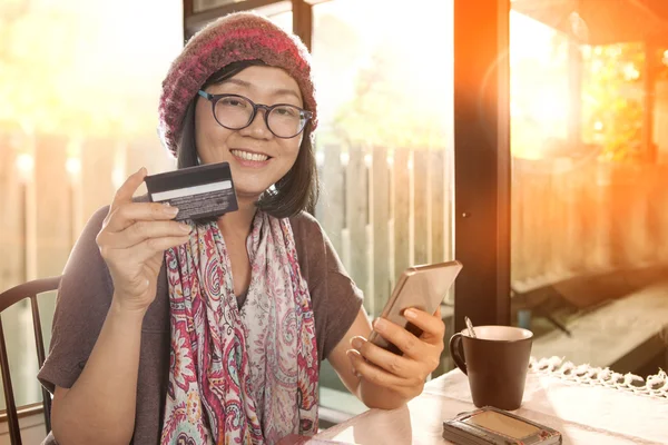 Felicidade emoção de asiático mulher com cartão de crédito na mão uso fo — Fotografia de Stock