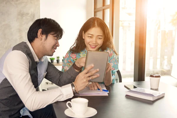 Aziatische jongere man en vrouw ontspannen met computer tablet in han — Stockfoto