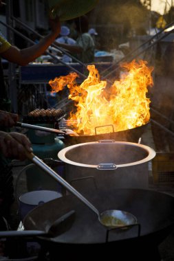 Bangkok Tayland 'da soba pişirirken sokak yemeklerinde ateş yanıyor.