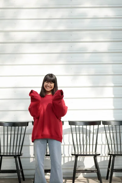 Azjatycki Nastolatek Noszenie Czerwony Sweter Stojący Pod Białą Ścianą — Zdjęcie stockowe