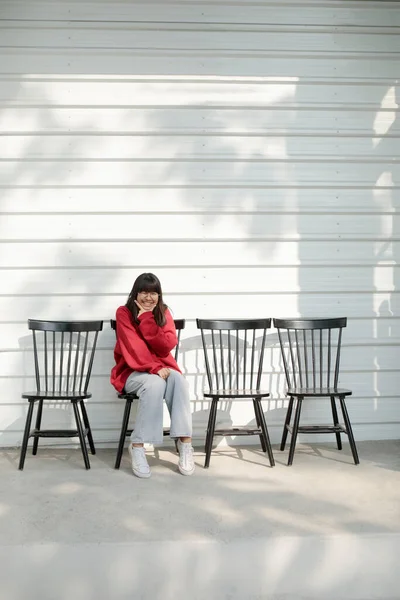Asijské Teenager Sedí Dřevěné Lavici Proti Bílé Zdi Pozadí — Stock fotografie