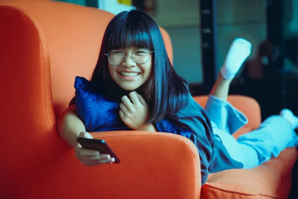 Asian Teenager Holding Smartphone Lying Sofa Home Living Room — Stok fotoğraf
