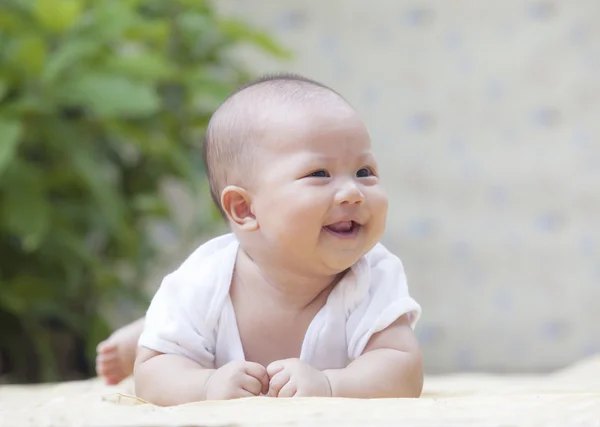 Faccia ravvicinata del bambino sorridente sdraiato sul morbido letto a casa terrazza — Foto Stock