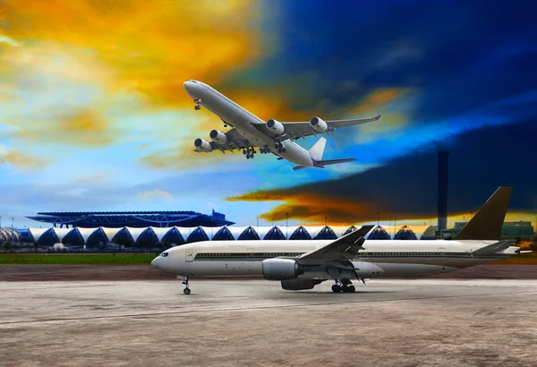 Jet plane flying over runways and beautiful dusky sky with copy — Stock Photo, Image