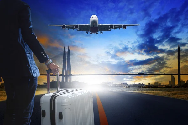 Young business man standing with luggage on urban airport runway — Stock Photo, Image